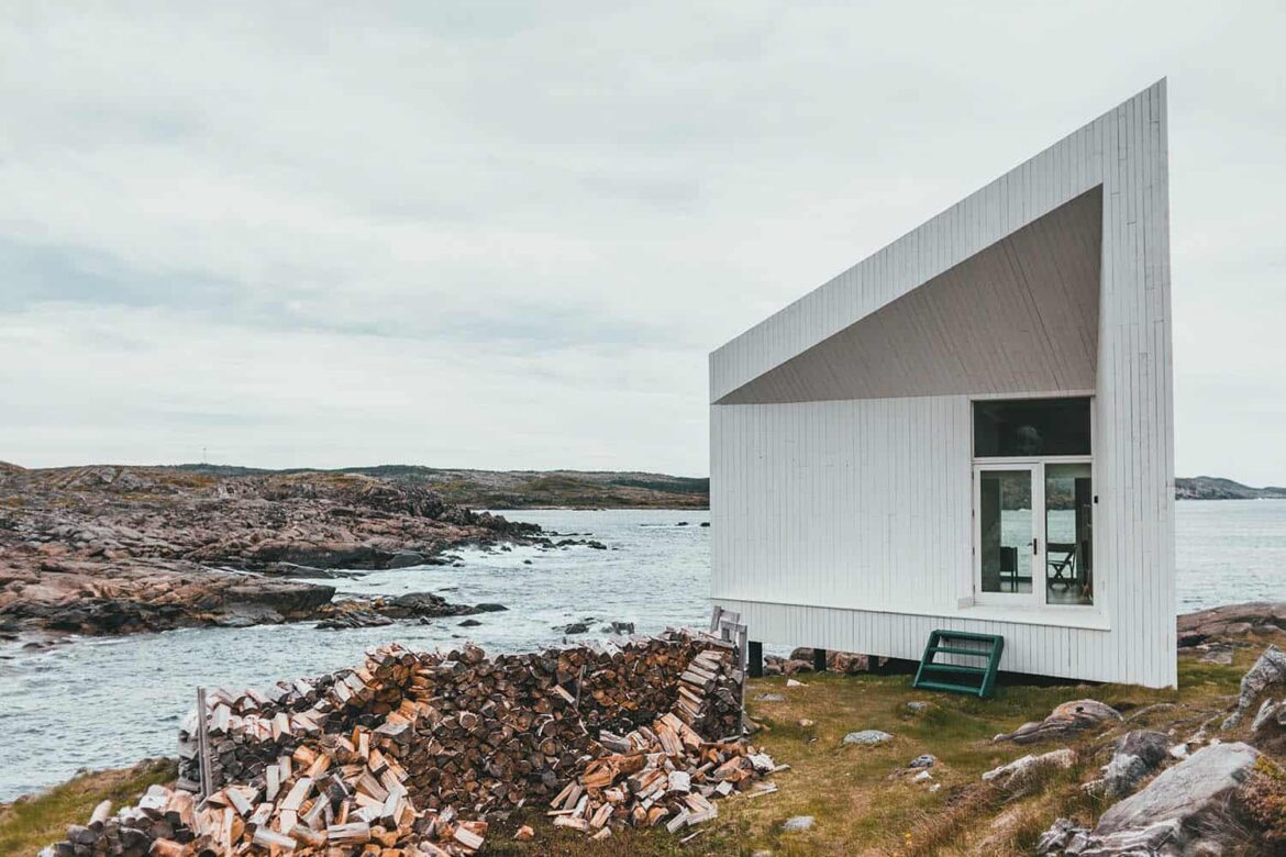 weißes, abstraktes Tiny House am Wasser