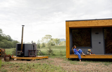 Frau ruht in der Natur in einem Tiny House