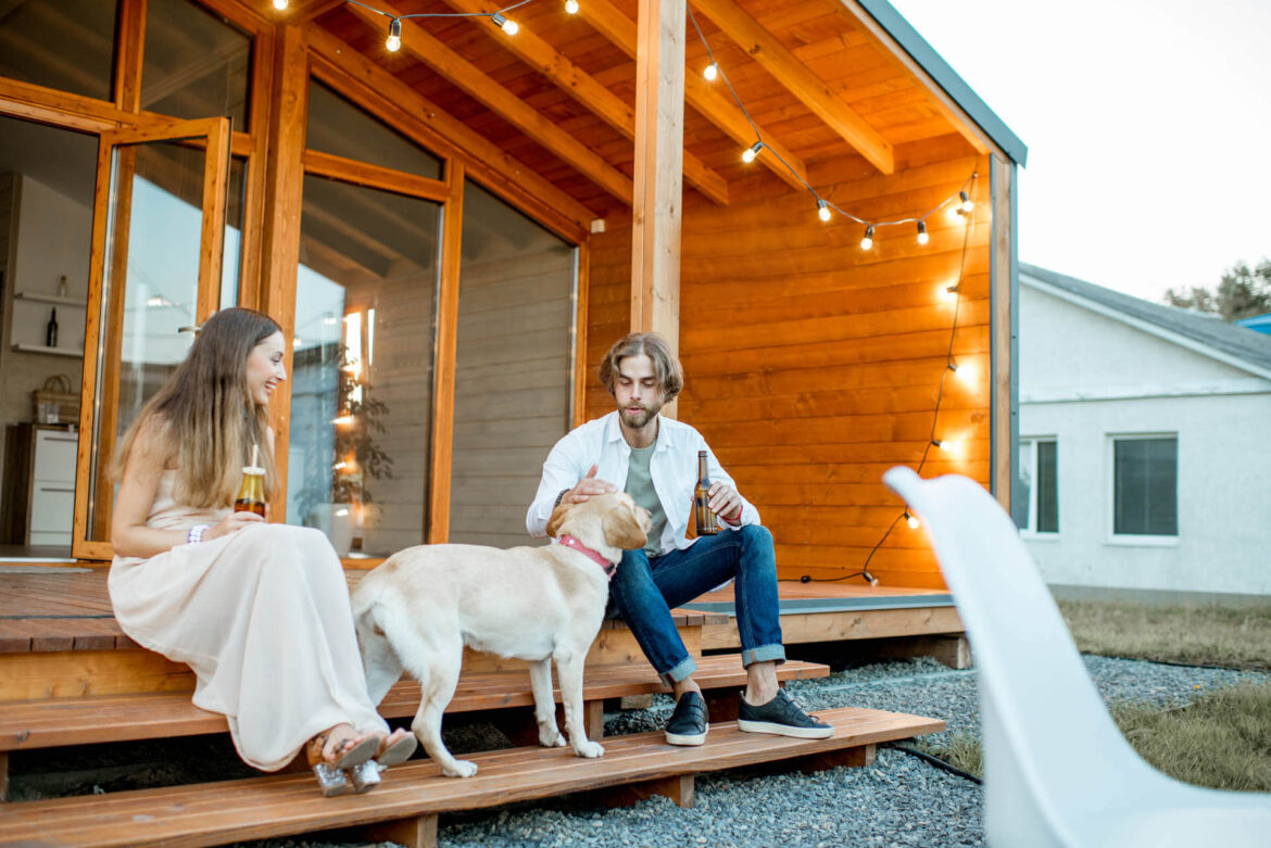 Paar mit Hund auf der Terasse eines Tiny Houses von Ikea in Holland