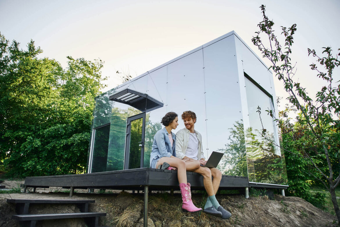 junges multiethnisches Paar sitzt auf Veranda eines Tiny House in Östereich